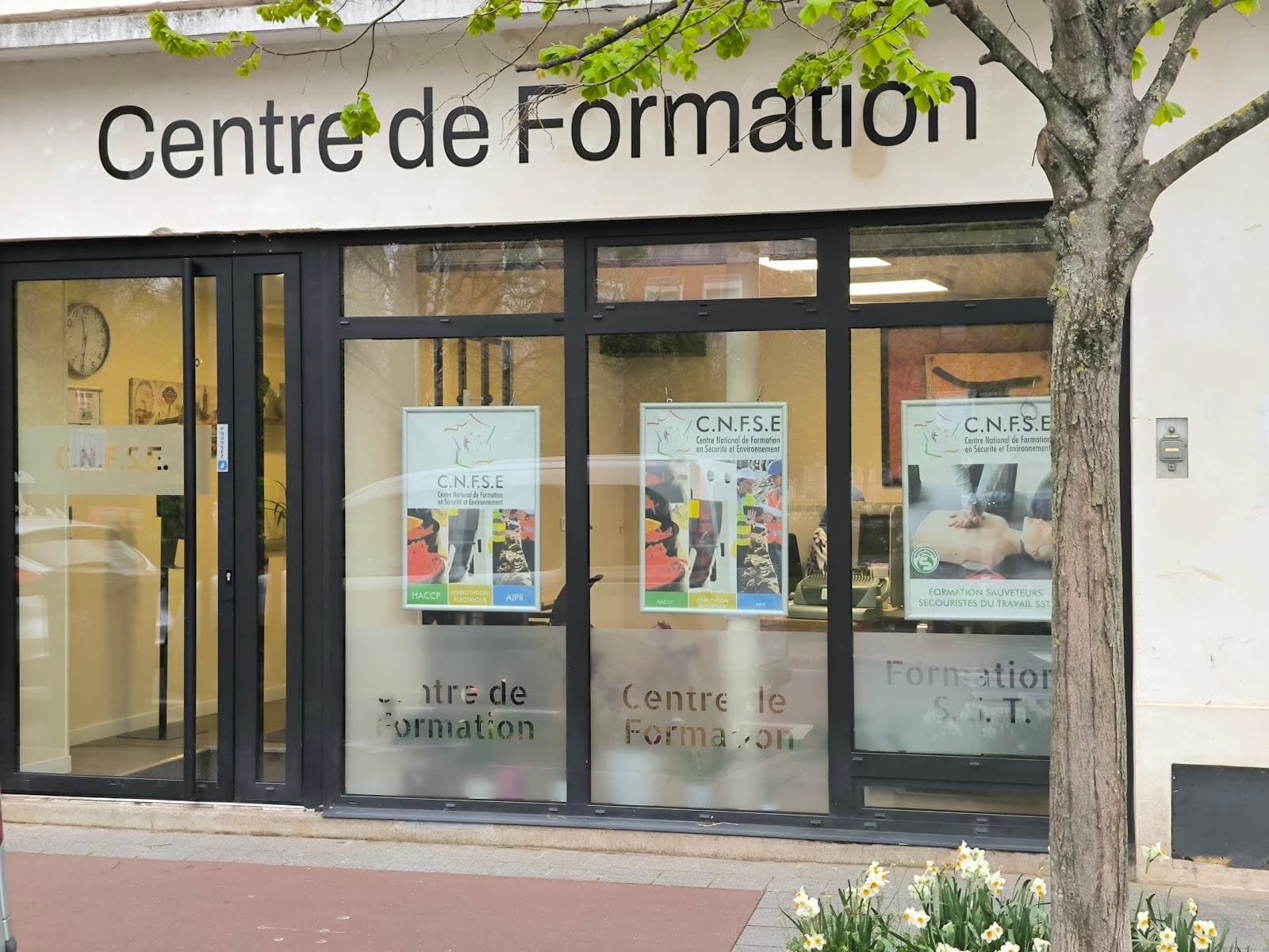 Vue rue du centre de formation CNFSE à Charenton-le-Pont — vitrines avec affiches AIPR et formation SST.